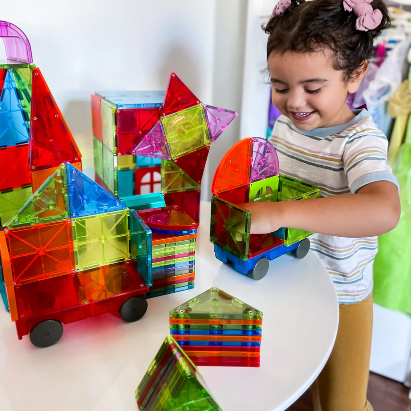 A kid building metropolis with magnetic tiles.