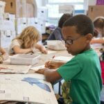 A group children studying attentively in a classroom.