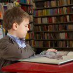 A boy reading in school's library.