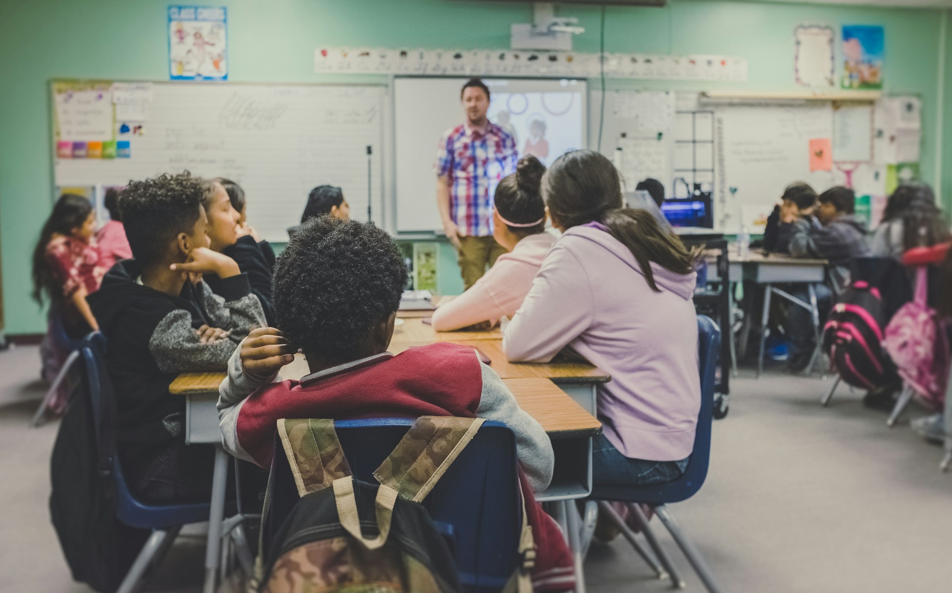 Classroom, teacher teaching to the students.