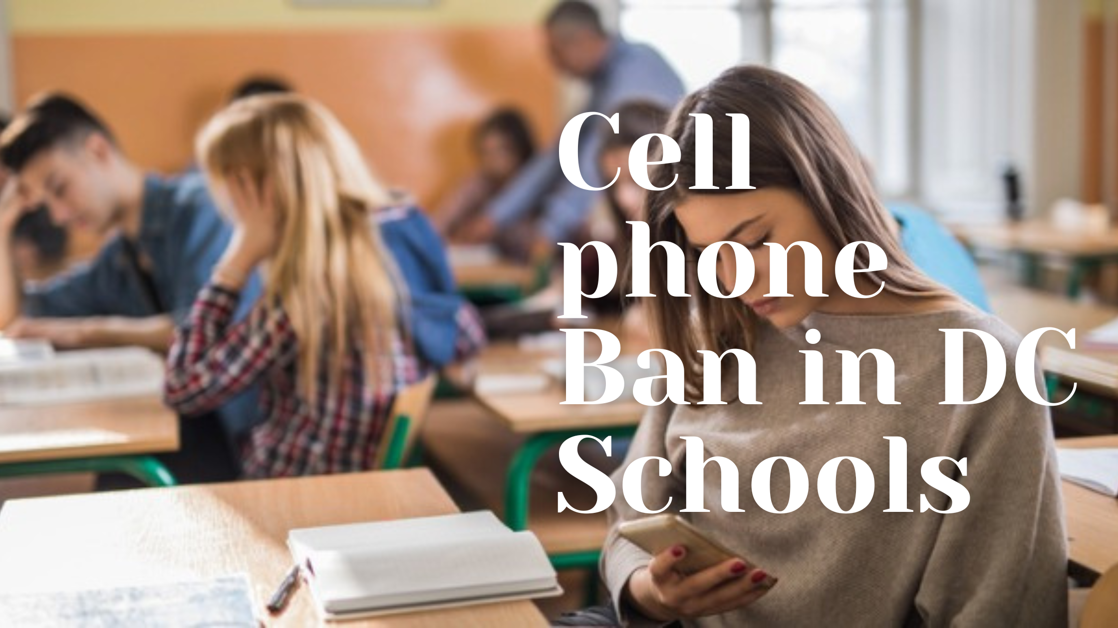 Student watching cell phone in a classroom.
