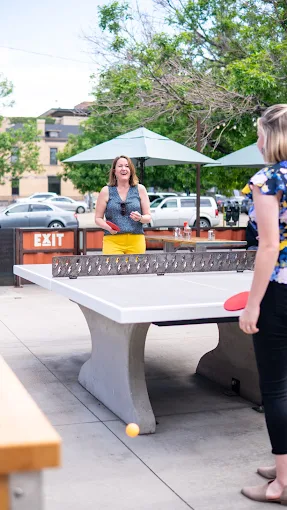 Visitors playing ping pong at Ace Eat Serve restaurant, Denver.